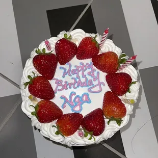 a birthday cake decorated with strawberries