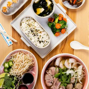 a variety of bowls of food on a wooden table