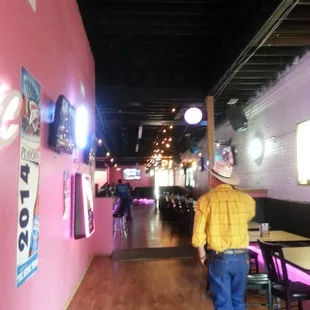 a man in a cowboy hat walking through a restaurant