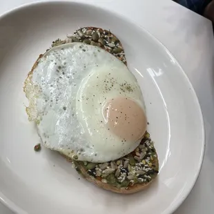 Avocado toast with a fried egg and seeds