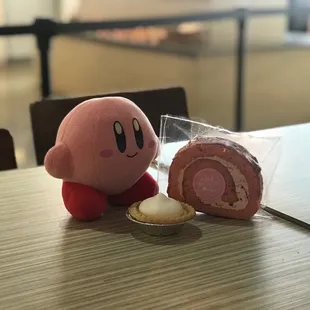 Kirby next to a strawberry Roll Cakes and tart!