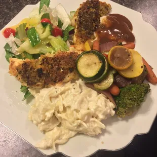 Delicious Parmesan Crusted Chicken with pasta alfredo, mixed veggies, salad, and other sides.