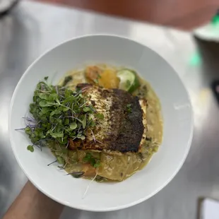 a person holding a bowl of food