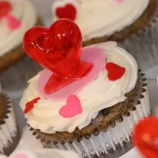 cupcakes with white frosting and red hearts