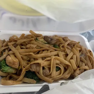 a container of noodles and broccoli