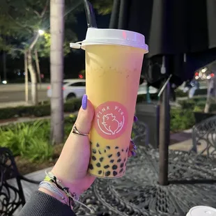 a person holding a cup of boba