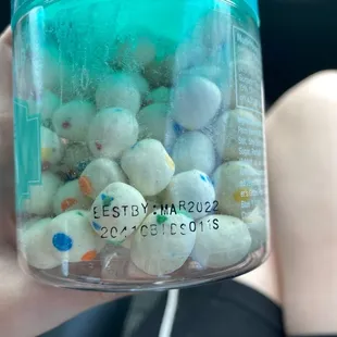 a person holding a jar of sprinkles