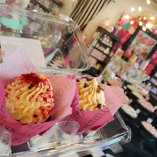 a person holding a cupcake in a plastic container