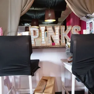 two chairs in front of a pink sign