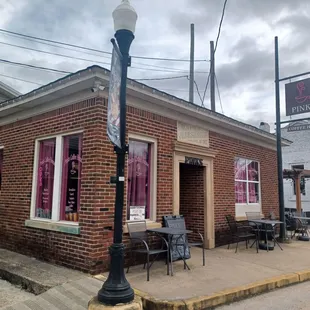 the outside of a restaurant with tables and chairs