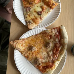 two slices of pizza on paper plates