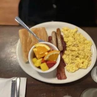 Scrambled eggs, sausage, bacon, fruit and cuban toast