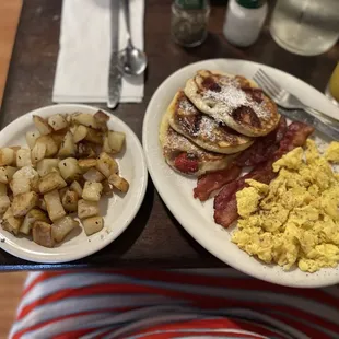 Pancake with strawberry, scrambled eggs, bacon and breakfast potatoes