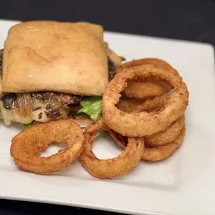 a burger and onion rings on a plate