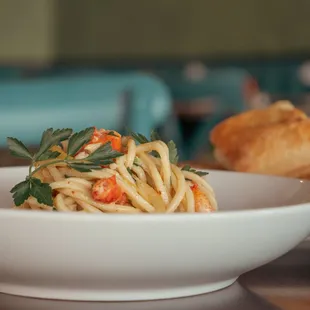 a bowl of pasta and bread on a table