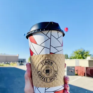 a hand holding a coffee cup