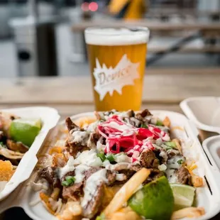 two trays of food and a glass of beer