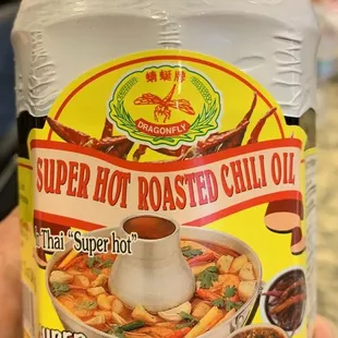 a hand holding a jar of super hot roasted chili oil