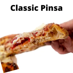 a hand holding a piece of pizza