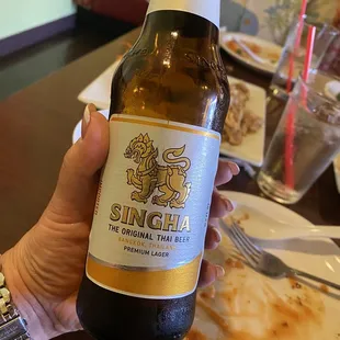 a hand holding a beer bottle