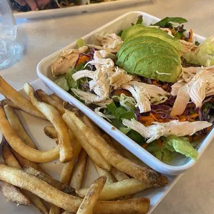 a plate of french fries and a salad