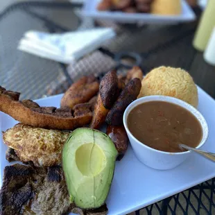 Montanero Platter- Steak, egg, plantains, pork skin, rice, beans, sausage, and avocado