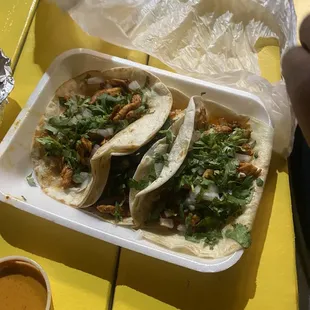 three tacos in a styrofoam container