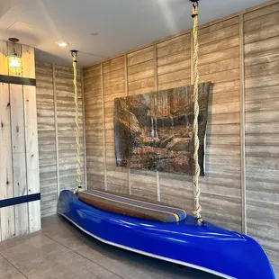 a blue canoe hanging from a rope