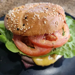 a hamburger with lettuce, tomato, and cheese