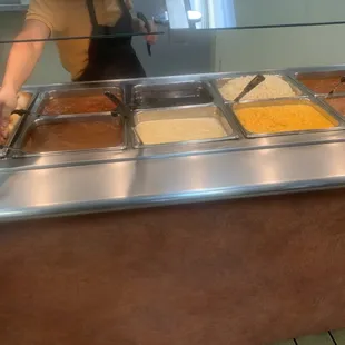 a woman preparing food in a buffet