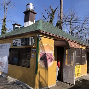 a yellow building with a green roof
