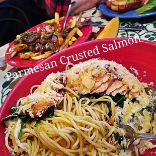 a plate of pasta with shrimp and spinach