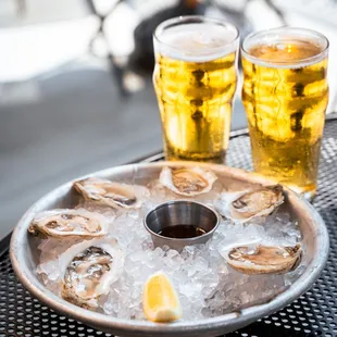 a tray of oysters and two glasses of beer