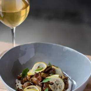 a bowl of food and a glass of wine