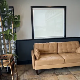 a tan leather couch in a waiting room