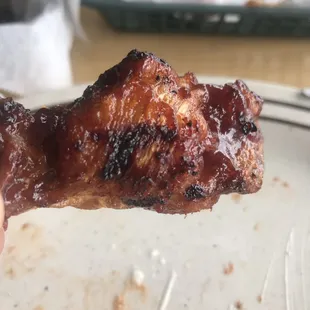 a hand holding a piece of meat