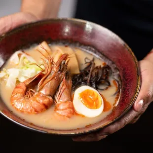 a person holding a bowl of food