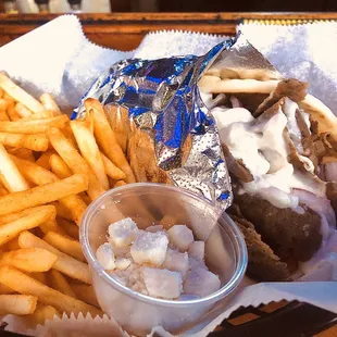 Lamb Gyro with tomato, onions, tzatziki sauce and feta cheese on the side.