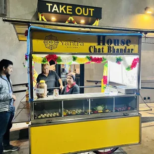 people standing in front of a food cart
