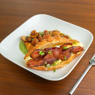 Pistachio's Bacon &amp; Egg Croissant served with roasted house potatoes &amp; tomatillo sauce
