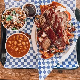 Brisket chilaquiles w sides of baked beans and esquite