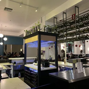 a bar with wine bottles on the shelves