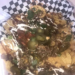 Brisket nachos with queso, bbq sauce, jalapeños, sour cream and cilantro