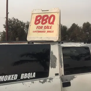 a bbq for sale sign on top of a truck