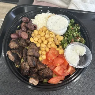 Rice bowl with Beef Kabab, feta, tomatoes, chickpeas, and tabbouleh.