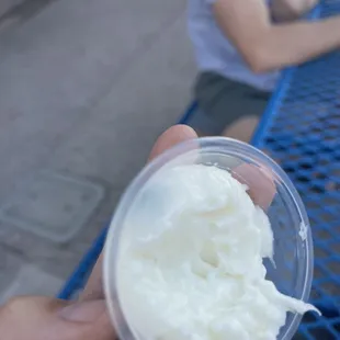 a hand holding a cup of ice cream