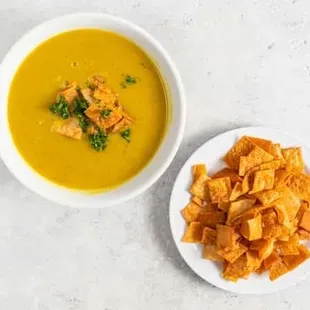 a bowl of soup and a plate of chips