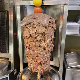 the meat being cooked on a skewer