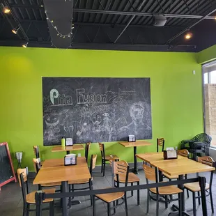 tables and chairs in front of a chalkboard