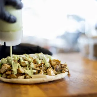 a person putting sauce on a pita